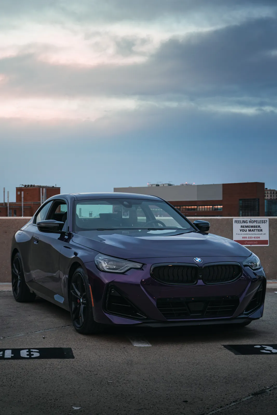 Purple BMW on a parking garage with dramatic sky (vertical)