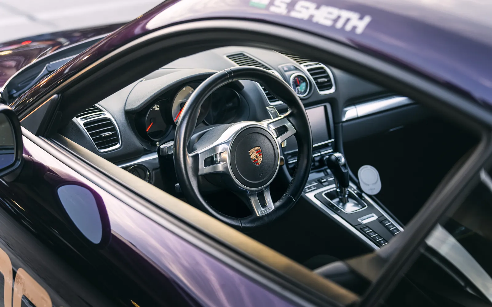 Close up of the Interior and steering wheel of a purple Porsche