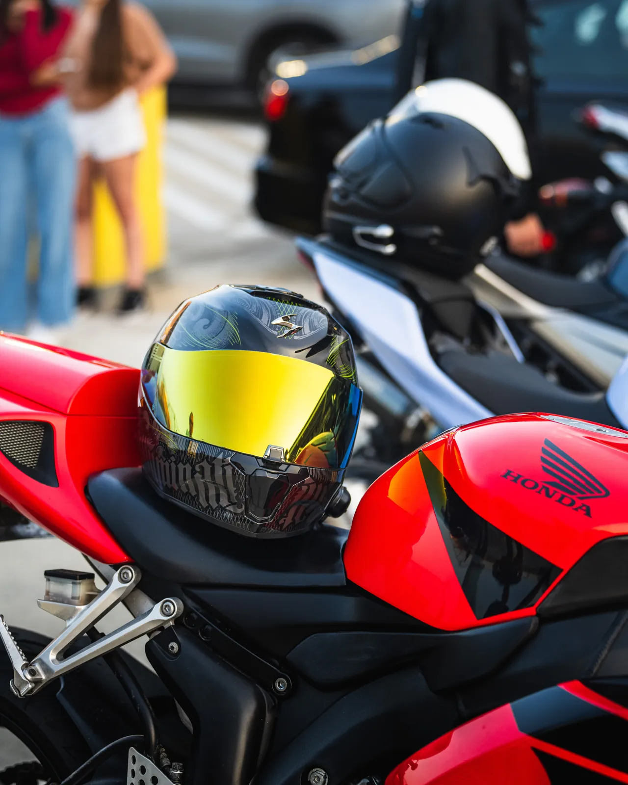 Black and Gold Visor Helmet sitting on a red Honda motorcycle